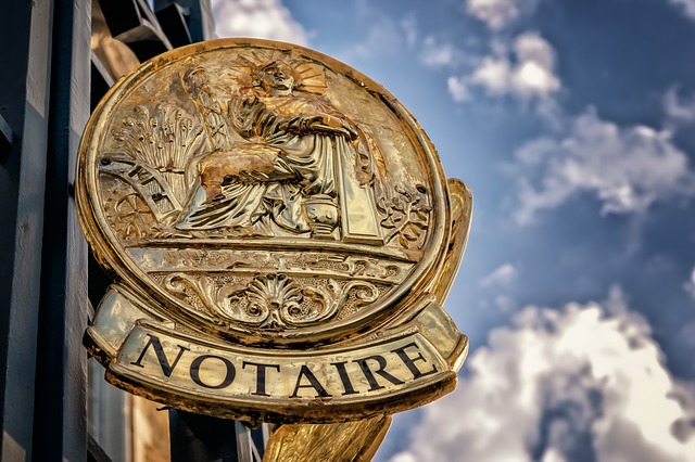 A "NOTAIRE" sign hands outside a shop front. This is an alternative spelling to the American "Notary"